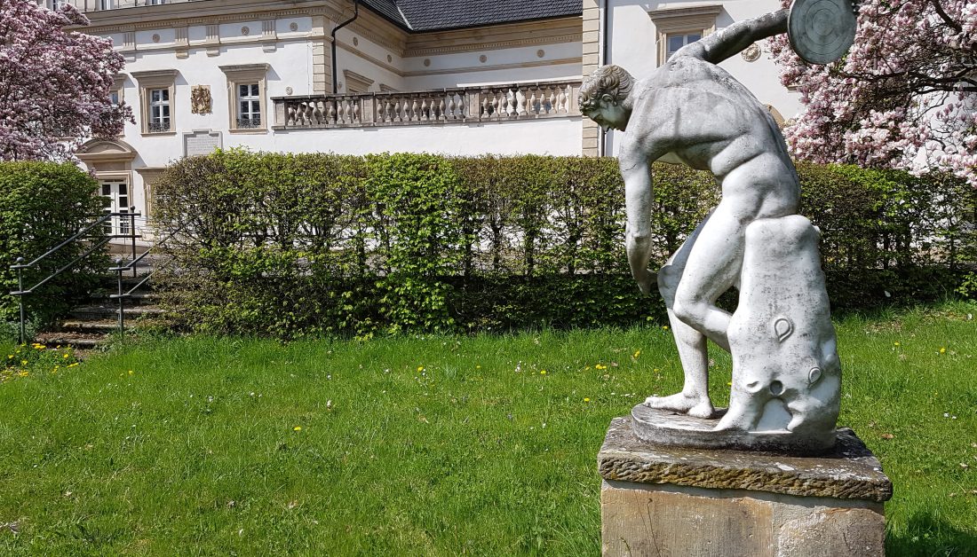 Klassische griechische Steinskulptur auf einem Podest in einem Schlosspark | Bildquelle: Gartentraum.de