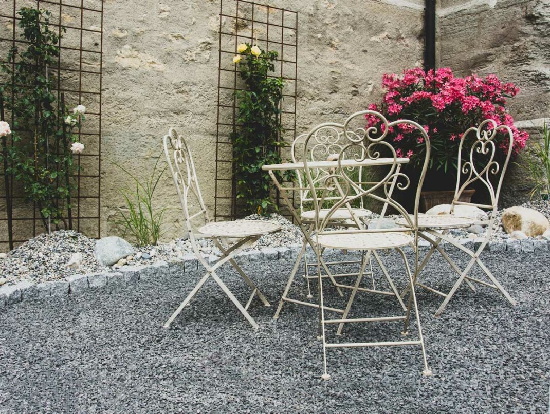 Romantisch gestaltete Terrasse mit Sichtschutz aus Naturstein und Pflanzen