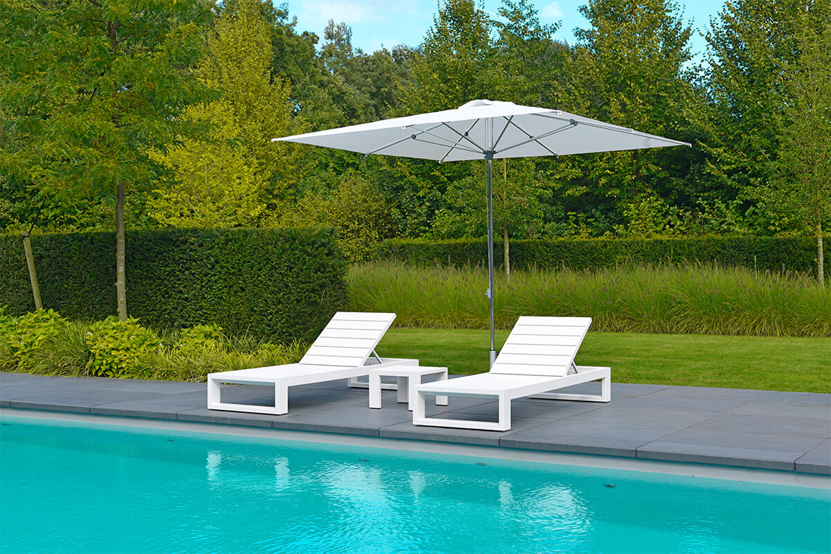 Liegestühle mit Sonnenschirm am Pool