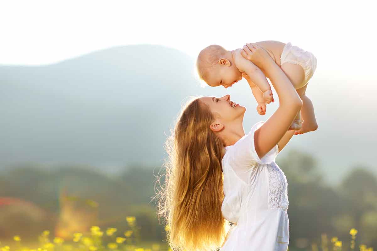 Junge Mütter freut sich zusammen mit Ihrem süßen Baby über den ersten Muttertag und die vielen Glückwünsche und Geschenke