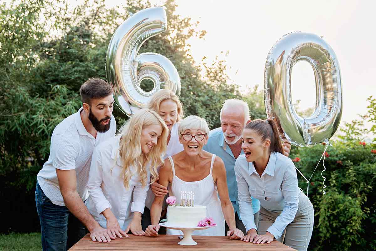Frau freut sich zum 60. über schöne Geburtstagswünsche mit Familie