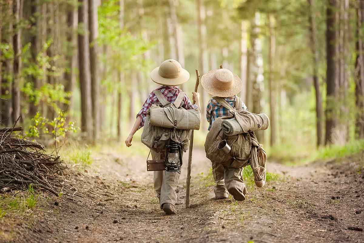 Zwei Kinder in Wanderkleidung im Wald