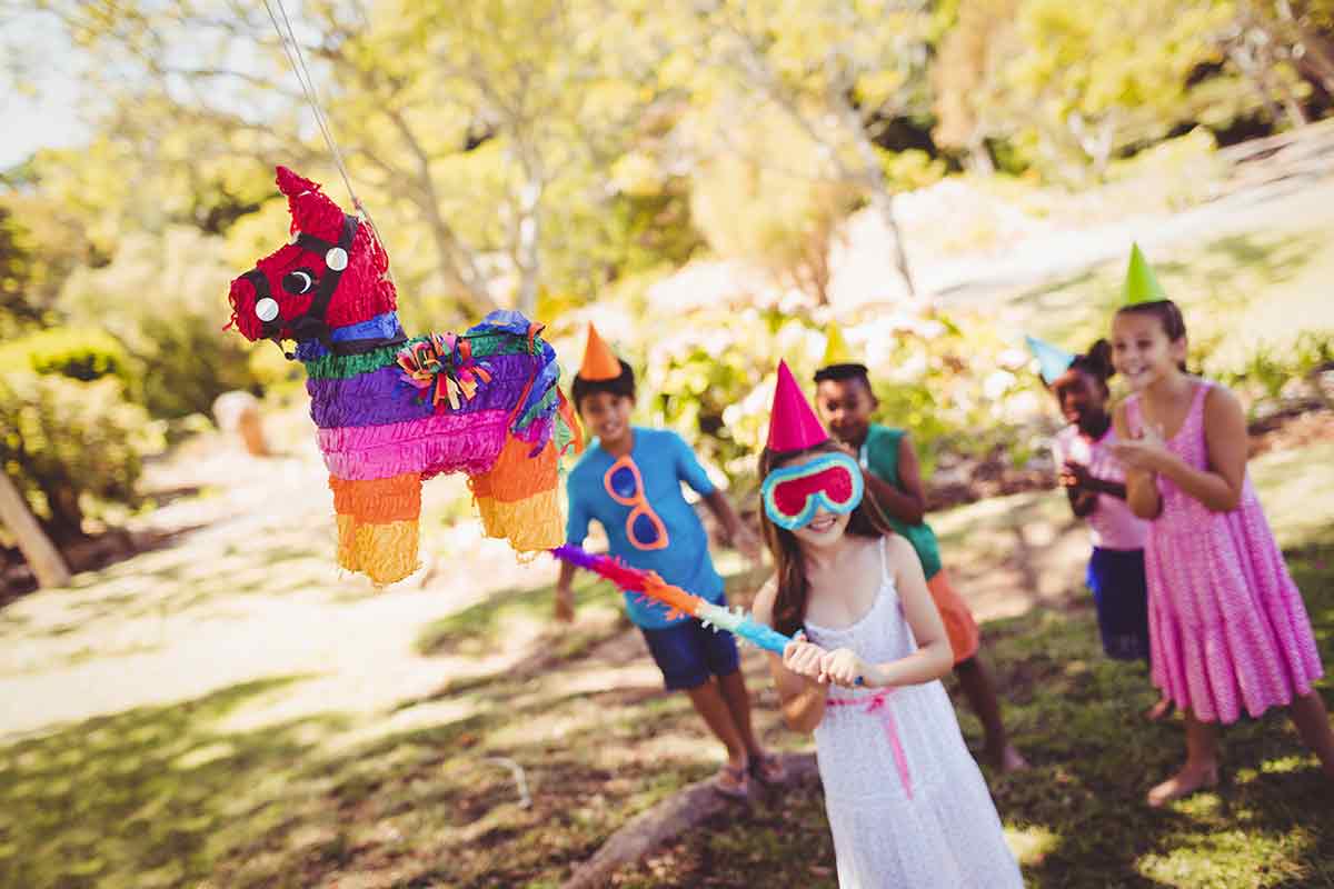 Kinder zerschlagen zur Geburtstagsfeier eine Pinata