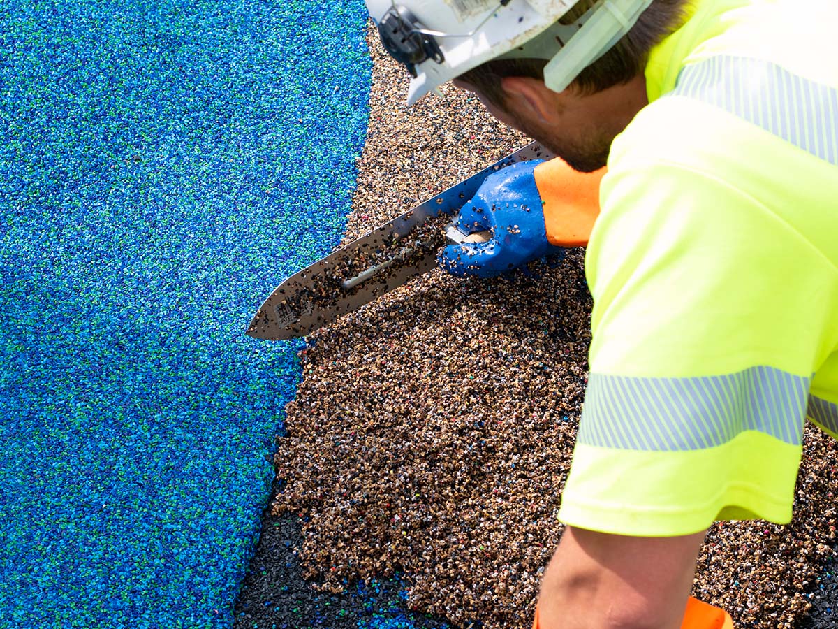 Bauarbeiter bearbeitet Boden auf Kinder-Spielplatz