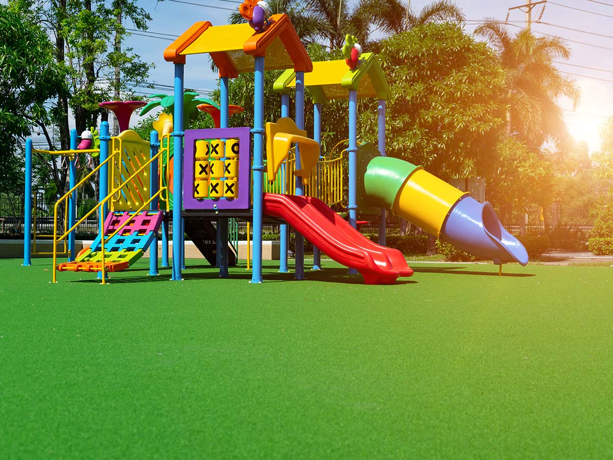 Bunter Kinder-Spielplatz aus Kunststoff auf grünem Rasen