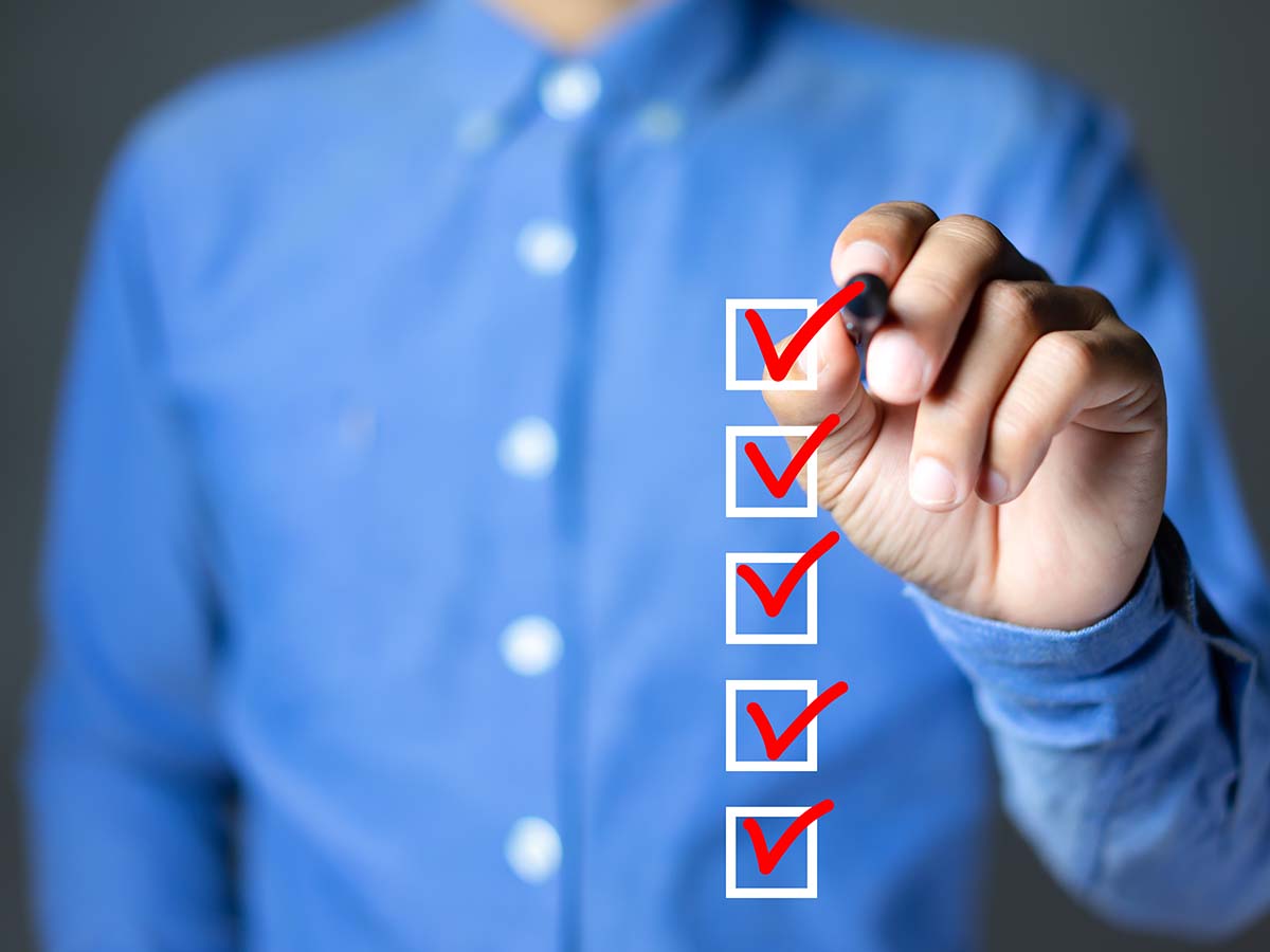 Mann in blauem Hemd hakt Checkliste ab 