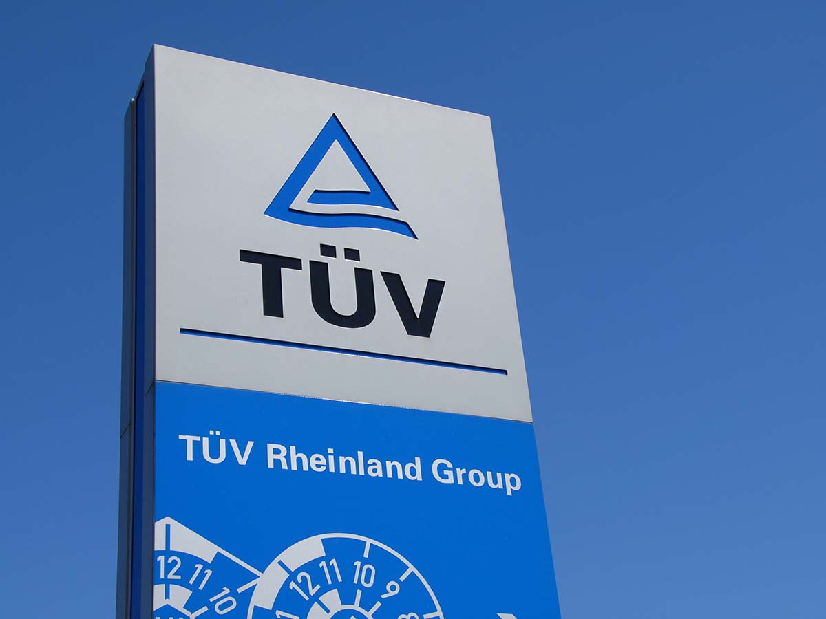 Schild der TÜV Rheinland Group vor blauem Himmel