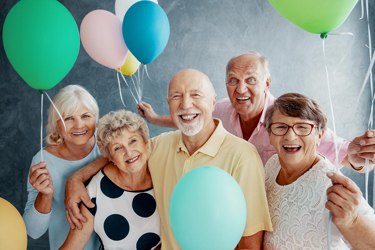 Senioren feiern zusammen Geburtstag mit Ballons