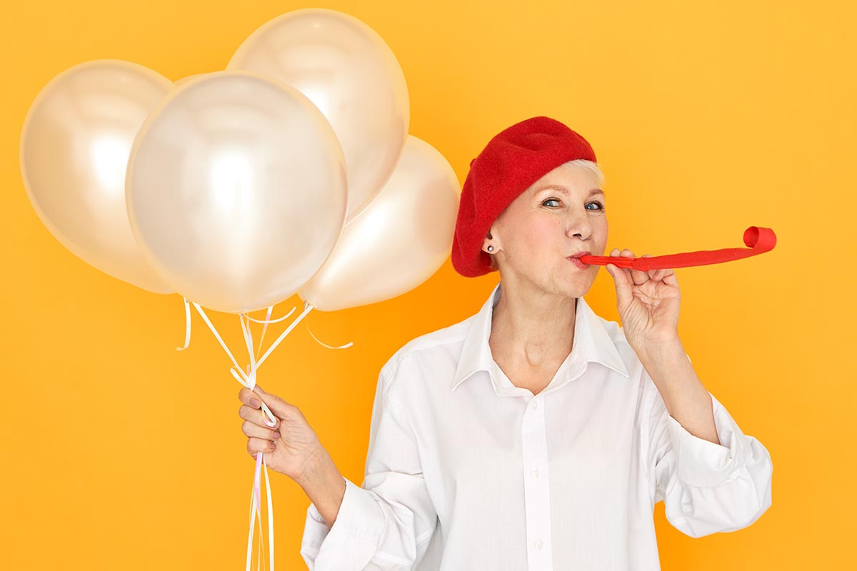 Frau mit Luftballons freut sich an Geburtstag