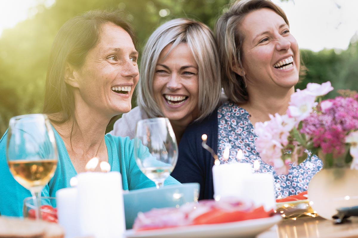 Frauen lachen auf Gartenparty über dumme & lustige Sprüche
