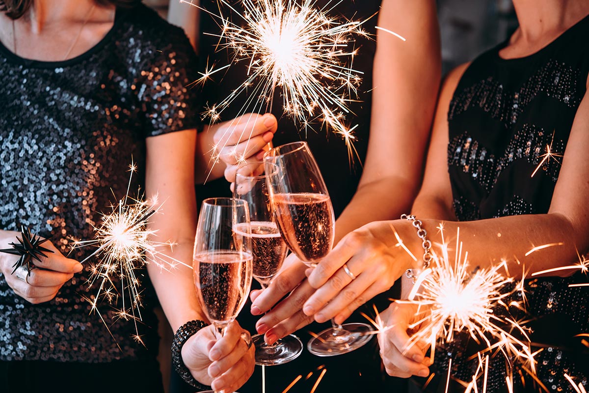 Frauen feiern mit lustigen Sprüchen,Sekt und Wunderkerzen Silvester