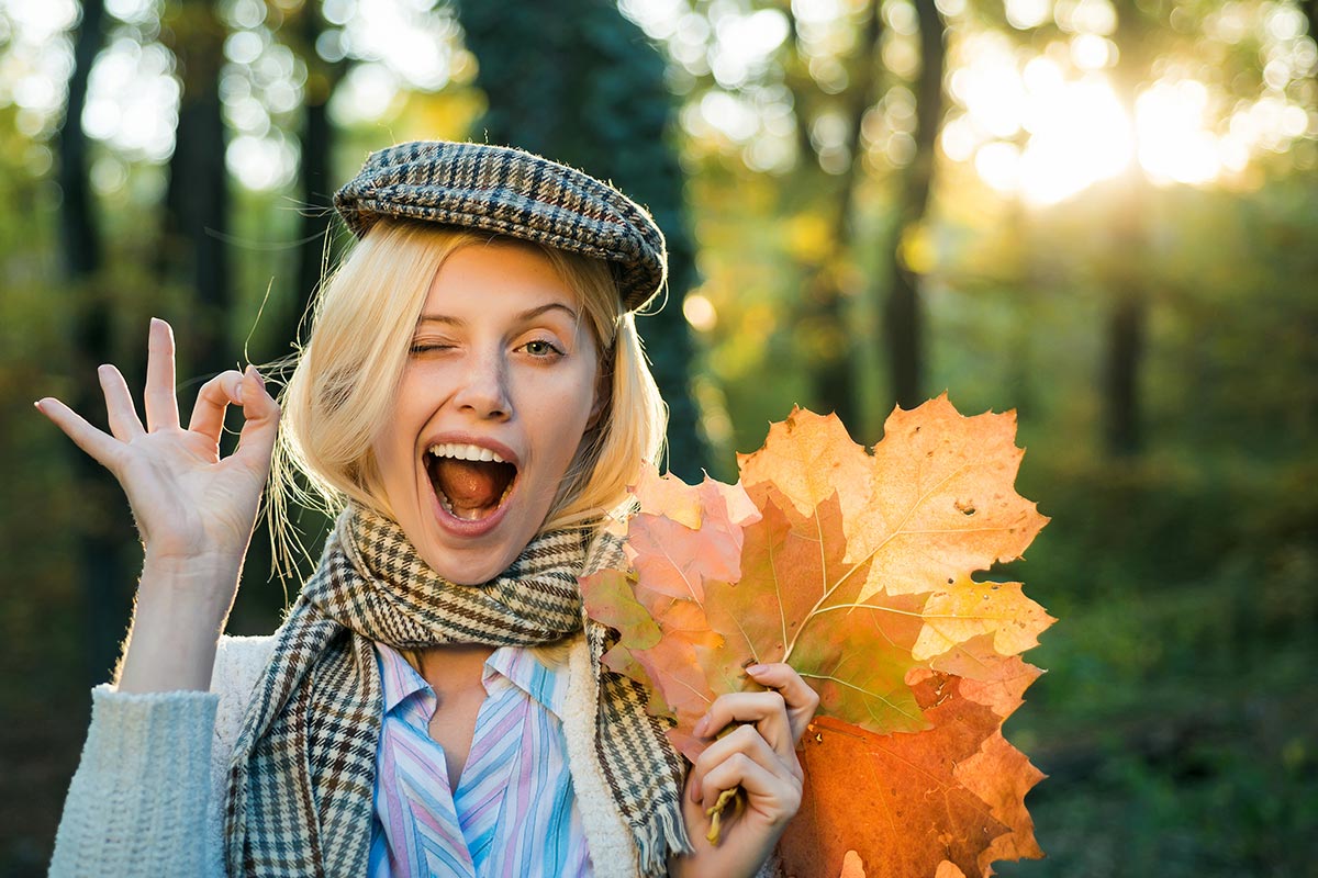 Junge Frau in Herbstwald mit farbigen Blättern