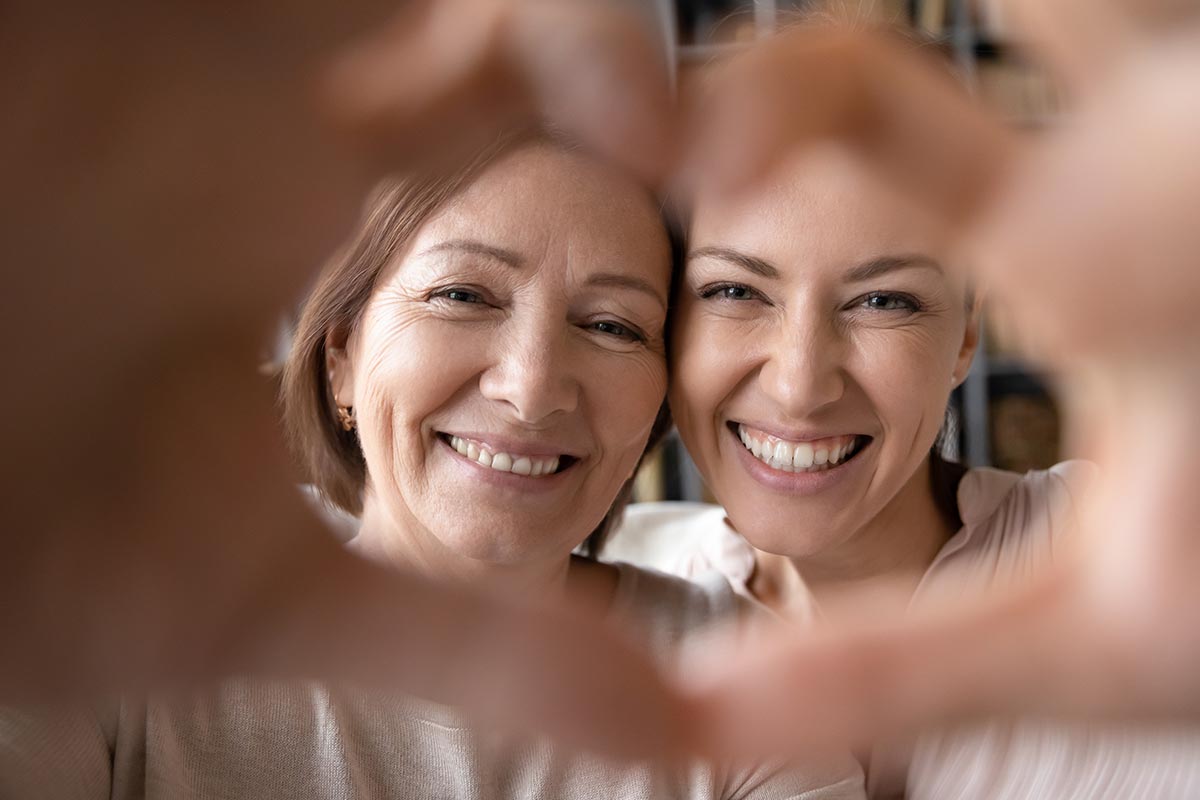 Mutter und Tocher formen Herz mit Händen 