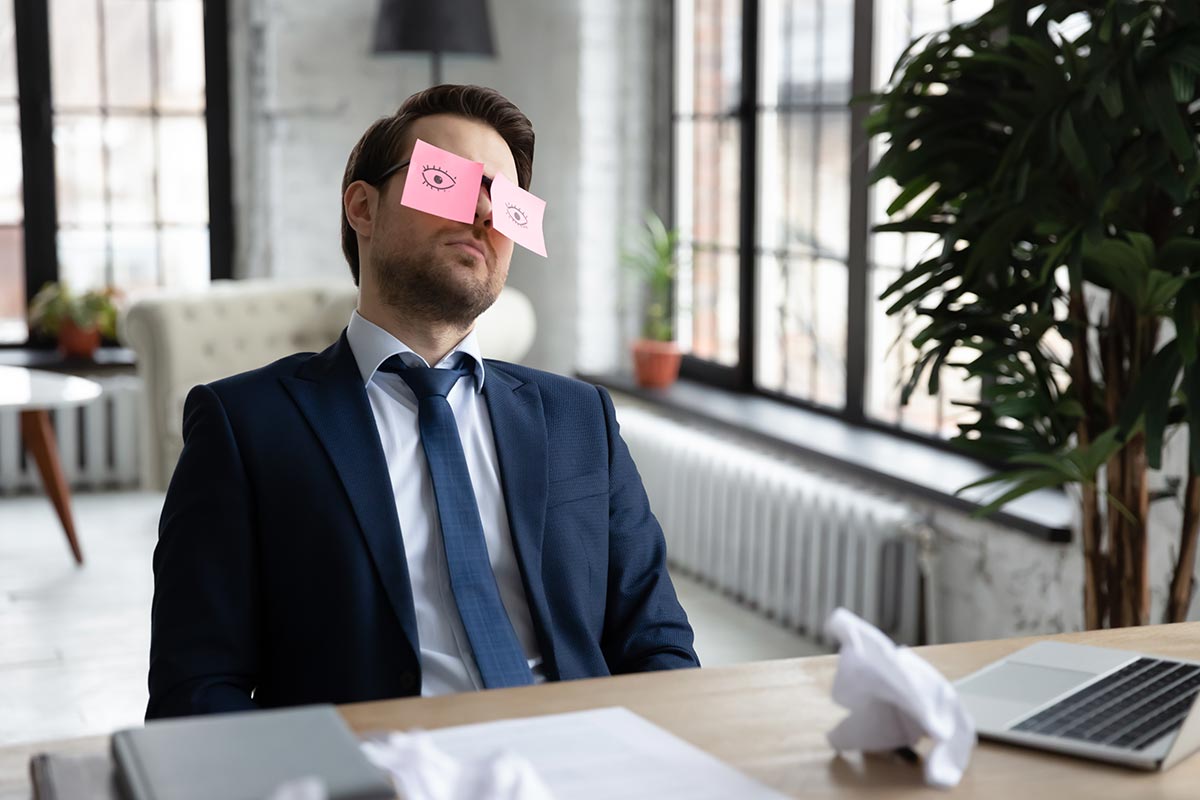 Geschäftsmann im Büro schläft am Schreibtisch