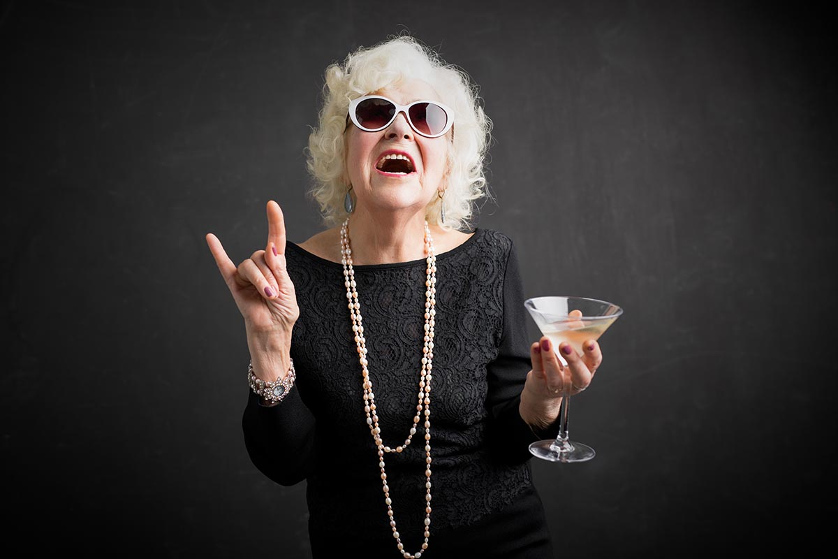 Coole Oma mit Cocktail lacht über lustige Rentner-Sprüche
