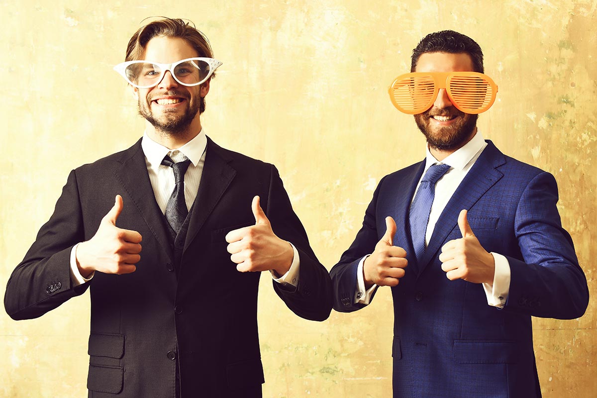 Zwei Geschäftsleute albern herum mit lustigen Brillen und witzigen Sprüchen