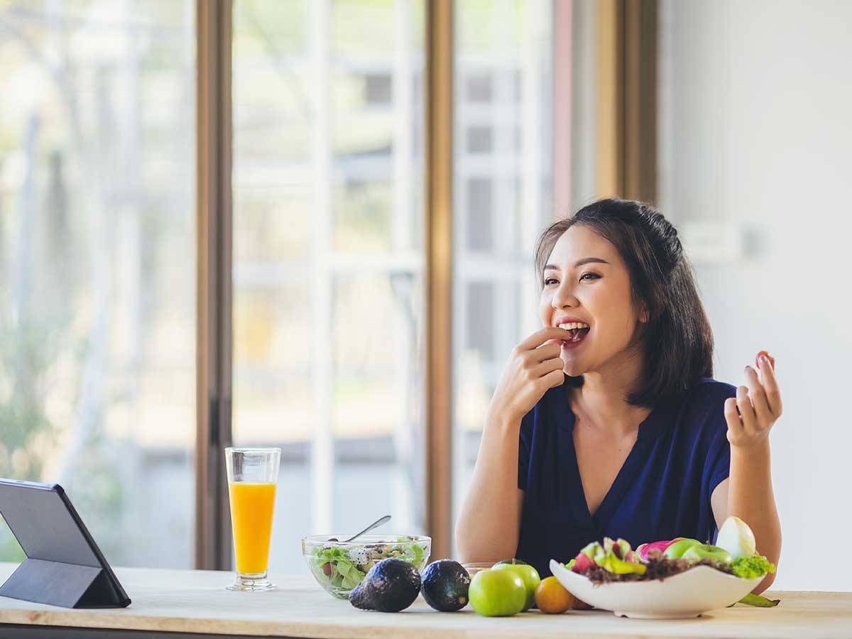 Frau isst Avocado und Gesundes