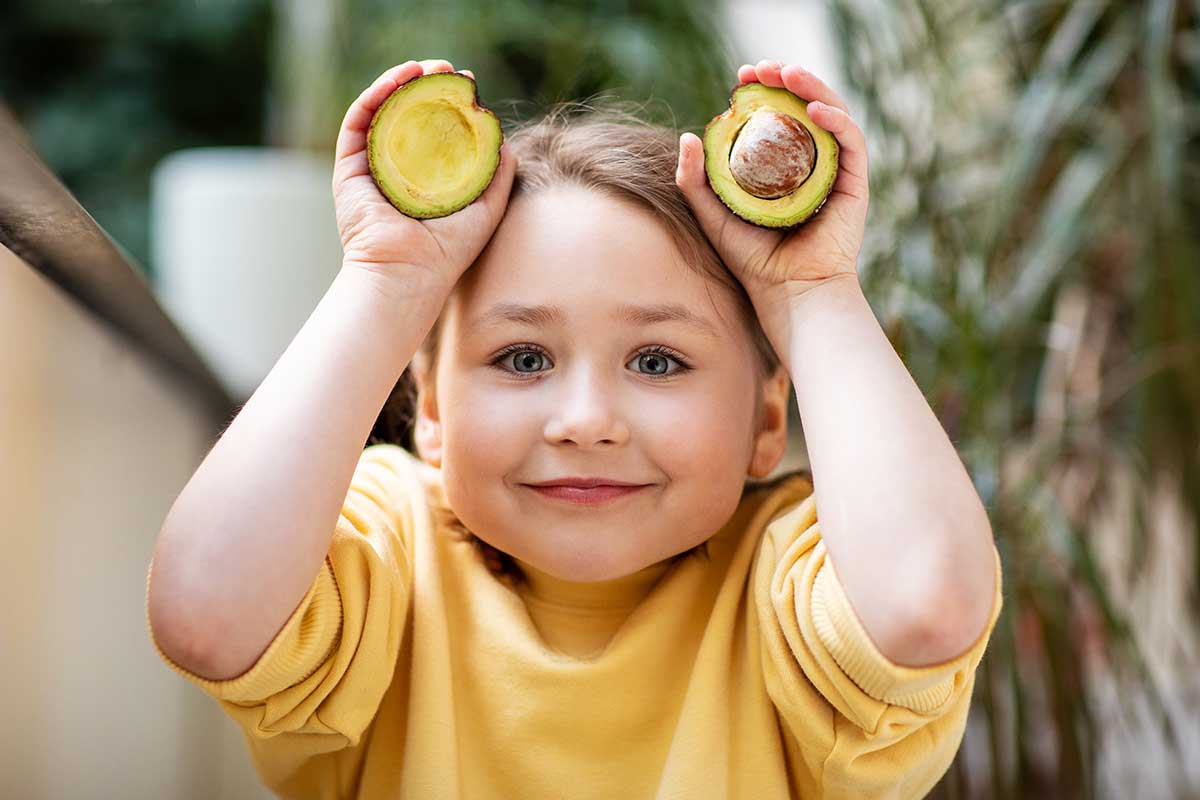 Mädchen hält Avocado-Hälften