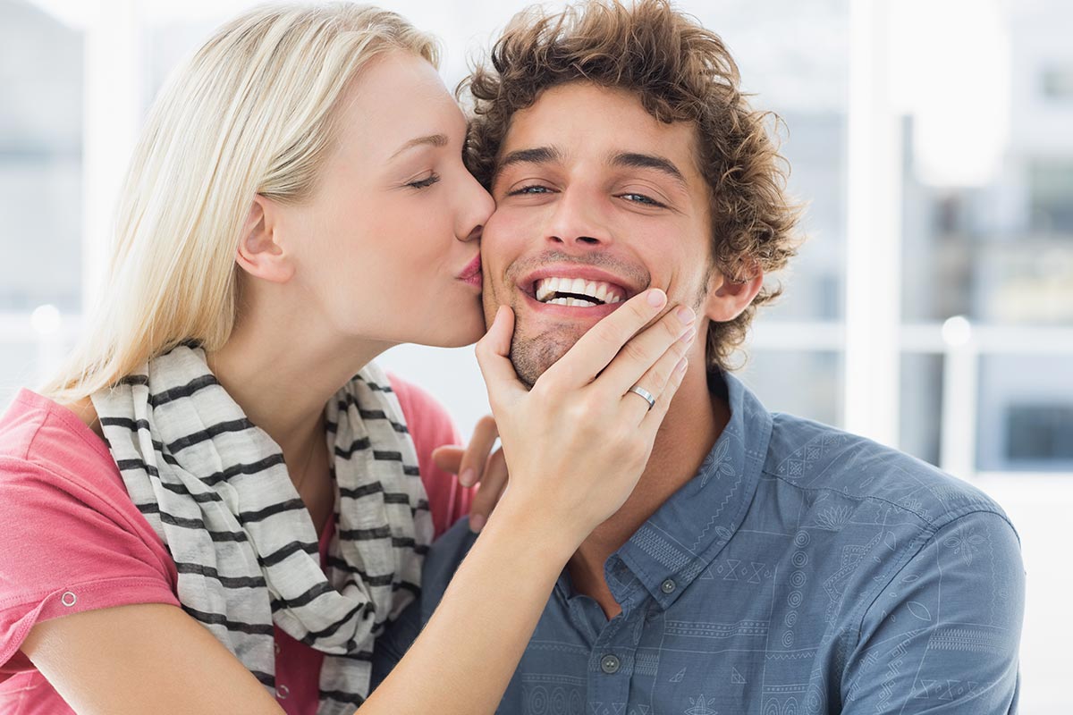 Mann kriegt Kuss auf Wange und freut sich über Liebessprüche
