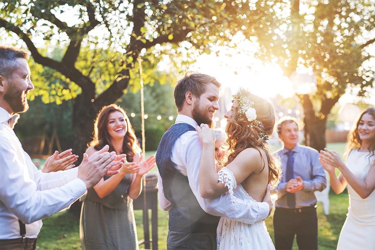Eherpaar auf Hochzeit in Garten freut sich über schöne Liebessprüche