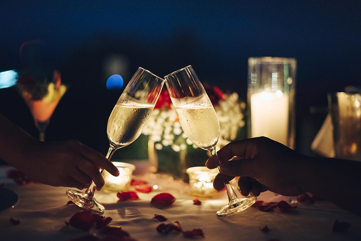 Romantisches Dinner im Kerzenlicht mit Sektgläsern und Liebesspruch