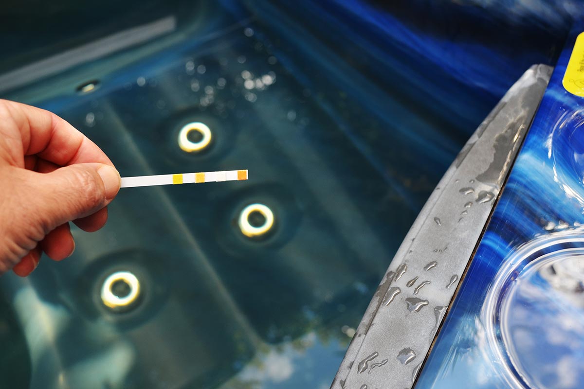 Person testet Wasserqualität in Whirlpool