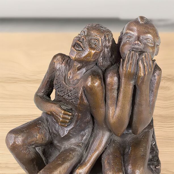 2 lachende Menschen sitzen auf Stein - Bronzeskulptur - Himmelhoch jauchzend