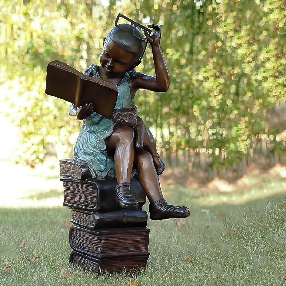 Image of Mädchen mit Brille sitzt auf Bücherstapel und liest aus Bronze - Tilly
