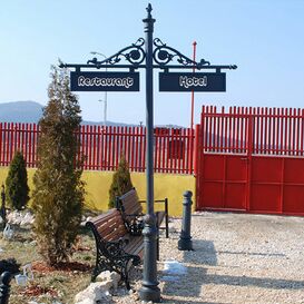 Stra�enschild aus Gusseisen mit Werbetafel und Ornamenten...